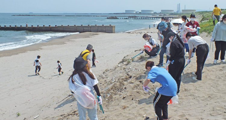 初夏の海岸で大学生と一緒に清掃活動